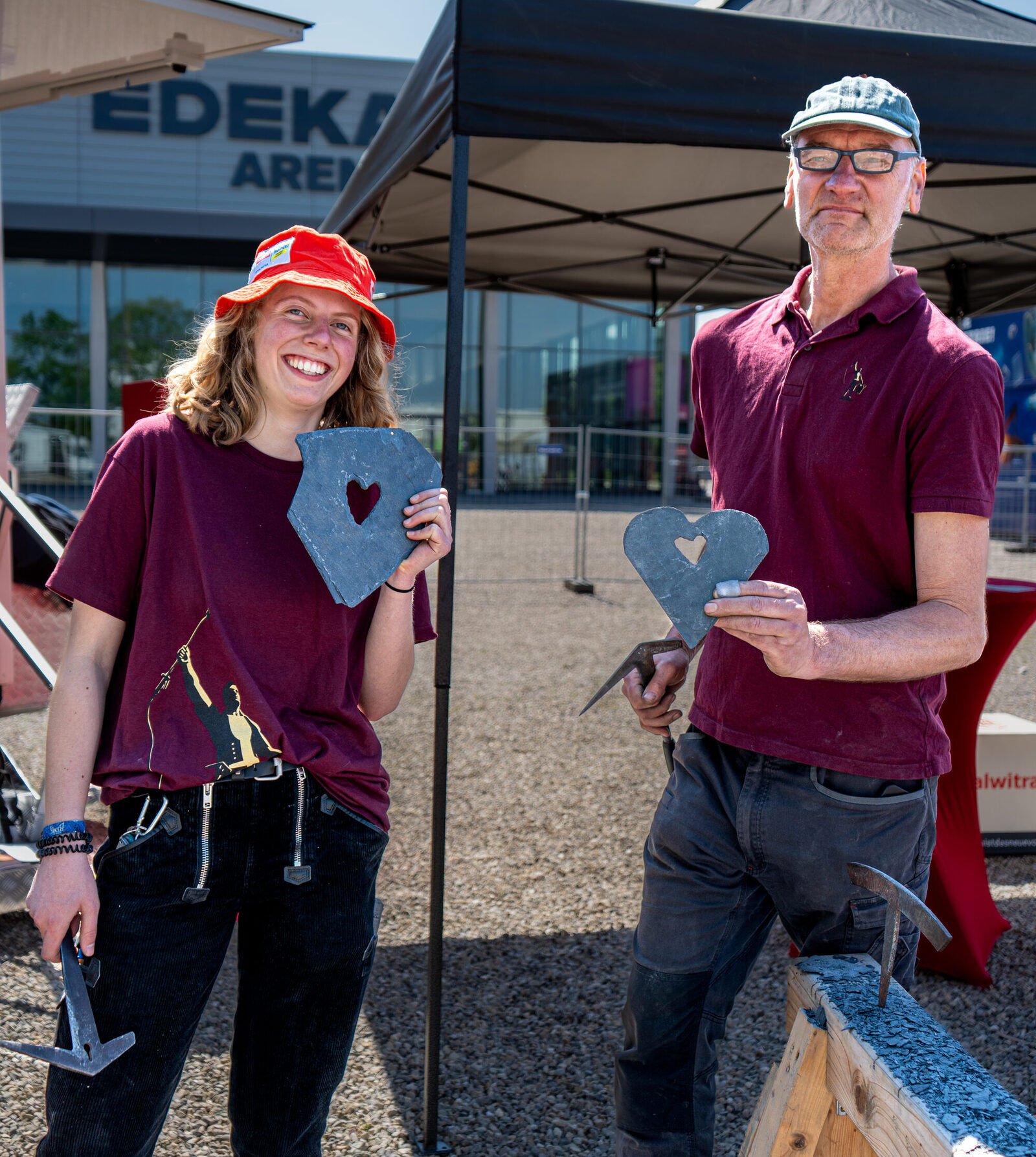 Peter und Lea mit Schiefer-Herzen vor dem Werkstattzelt